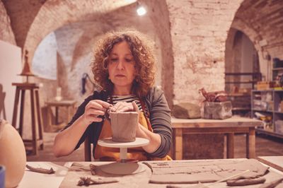 Monica modella un vaso all'interno del laboratorio di Sant'Agata.