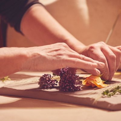 Monica pressa dei fiori su una lastra d'argilla.